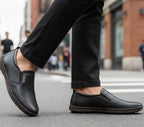 Person wearing black loafers on a city street