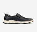 Black slip-on shoe with a white sole on a light gray background