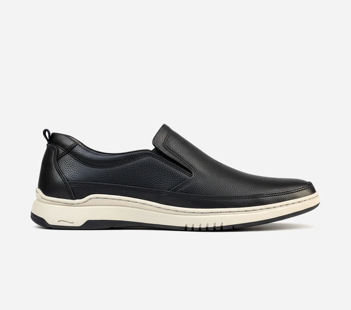 Black slip-on shoe with a white sole on a light gray background