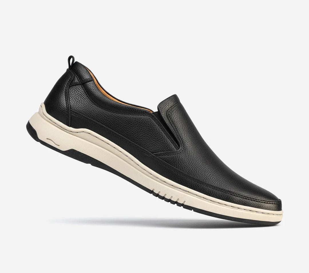 Black slip-on shoe with a white sole on a light gray background