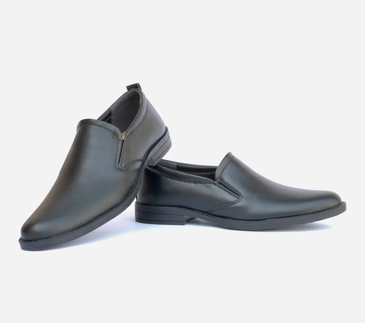 Pair of black slip-on shoes on a light gray background