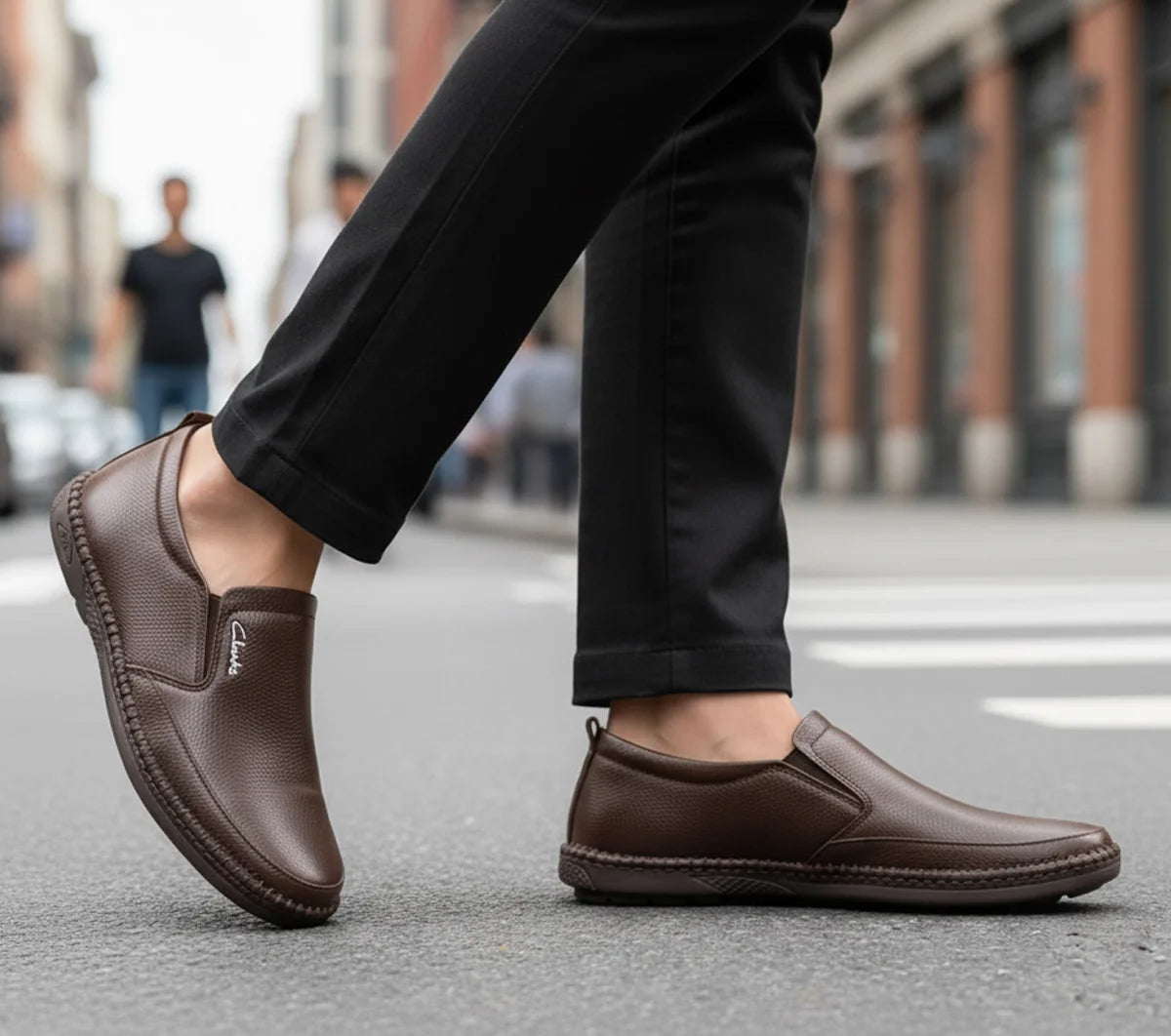 Person wearing brown loafers on a city street