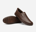 Brown slip-on shoes with a visible brand logo on a light gray background
