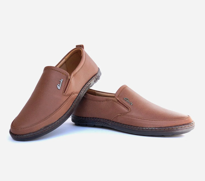 Pair of brown slip-on shoes on a light gray background