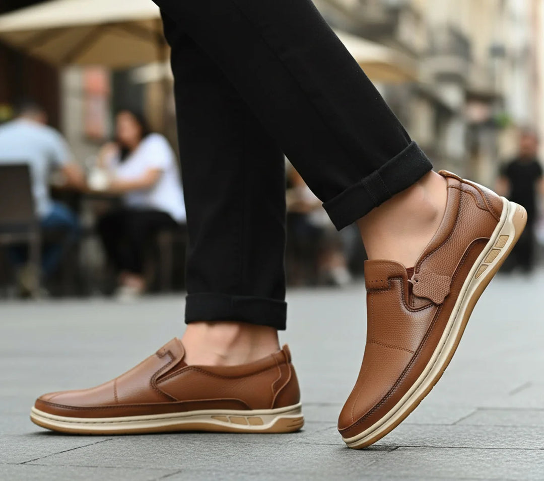 Brown loafers worn on a city street with blurred people in the background