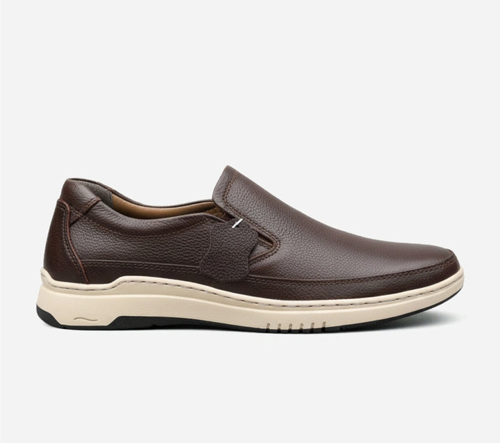 Brown slip-on shoe with a white sole on a light gray background